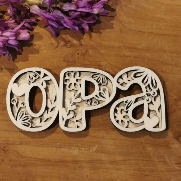 Schriftzug „Opa“ aus Holz oder Papier mit naturfarbener oberer Schicht und dunkler Rücklage. Dekorativ arrangiert auf Holz – schöner Hingucker für Vatertag oder Opa-Geschenke.
