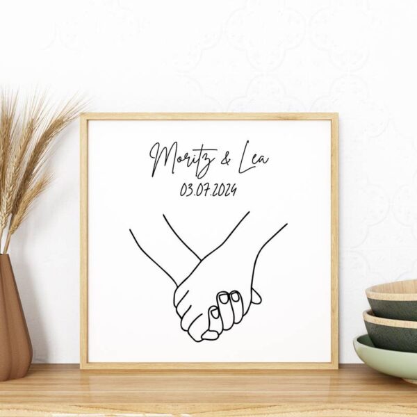 Bilderrahmen mit Line-Art-Händchenmotiv und personalisierbarem Namenstext „Moritz & Lea“, romantisch auf Holz dekoriert.