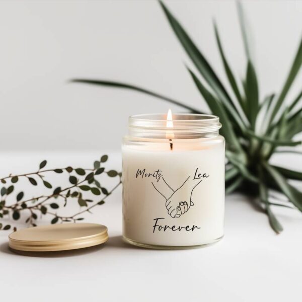 Duftkerze mit linearem Hand-in-Hand-Motiv und dem Schriftzug „forever“, daneben Pflanze, ideal als romantisches oder symbolisches Geschenk.