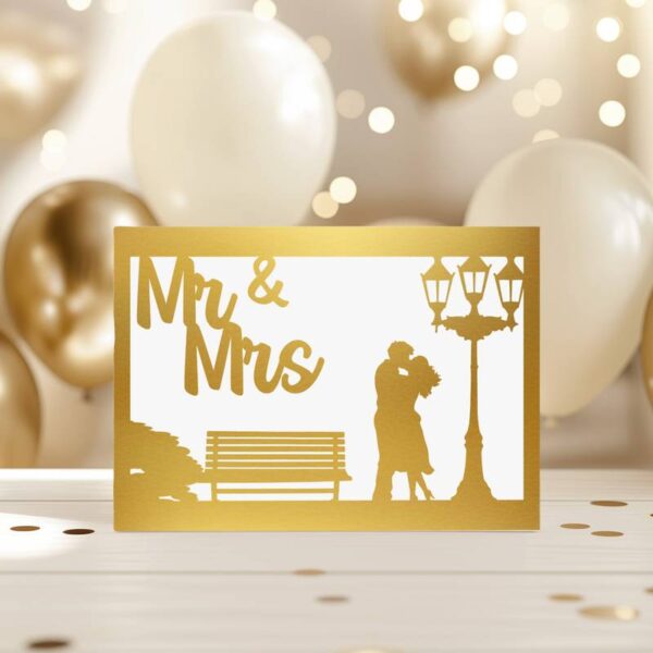 Goldfarbene Hochzeitskarte mit Silhouette eines Paars neben einer Bank und einer Laterne, daneben der Schriftzug „Mr & Mrs“. Hintergrund mit weißen und goldenen Luftballons – elegant und festlich.