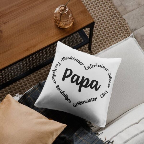 Dekokissen mit dem Papa-Herzdesign, liegend auf einer Couch in einem gemütlich eingerichteten Wohnraum.