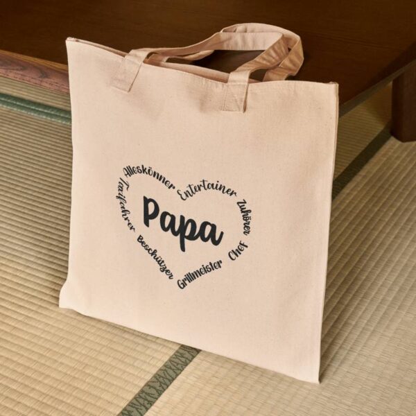 Kleiner Stoffbeutel mit dem Herzmotiv "Papa", stehend auf dem Boden – ideal als personalisiertes Geschenk oder Aufbewahrung.