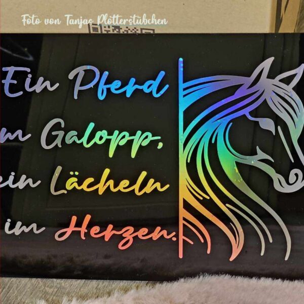 Plottdatei auf schwarzer Acrylplatte, gestaltet mit glänzender Hologrammfolie in Regenbogenschimmer. Der Pferdekopf und der Schriftzug wirken edel und lebendig.