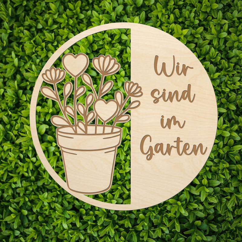 Rundes Holzkürschild SVG mit Blumentopf links, Gravur ‚Wir sind im Garten‘ rechts, Hintergrund mit grünen Blättern, digitales personalisierbares Türschild