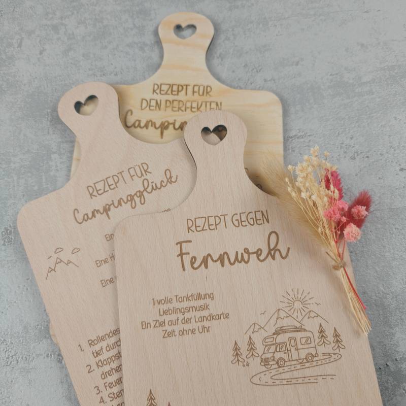 Detailansicht der selbst gelaserten Tablett-Halterung aus Holz, in der mehrere gravierte Camping-Rezepte im Hochformat dekorativ aufbewahrt werden.