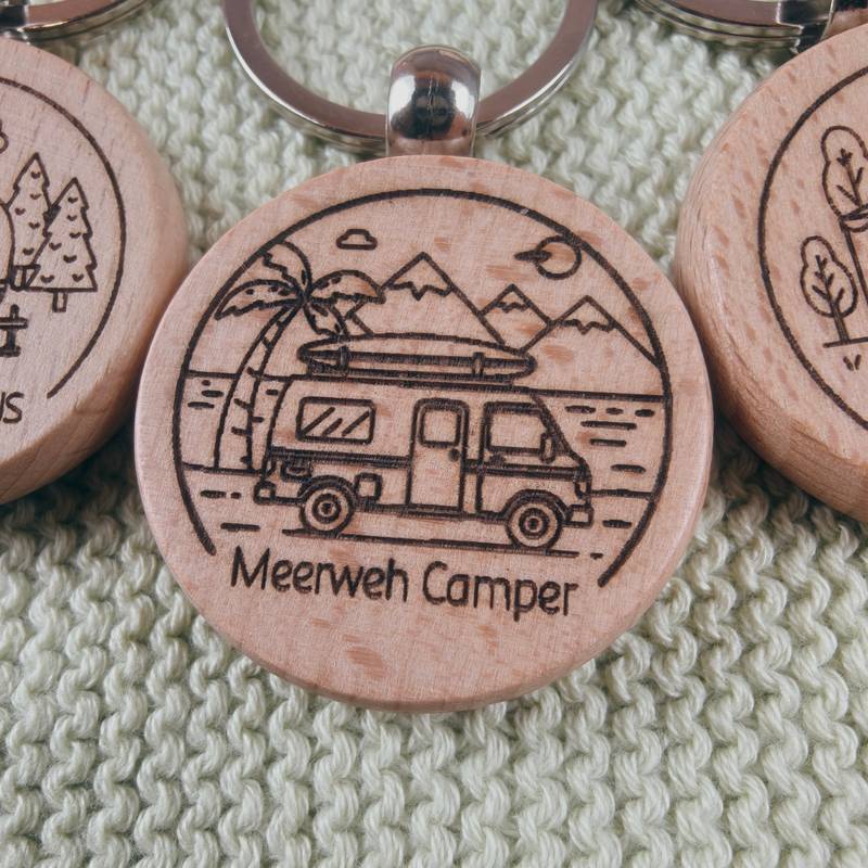 Fokus auf das Design „Meerweh Camper“ auf einem runden Holzrohling, platziert auf einem grauen Naturstein.