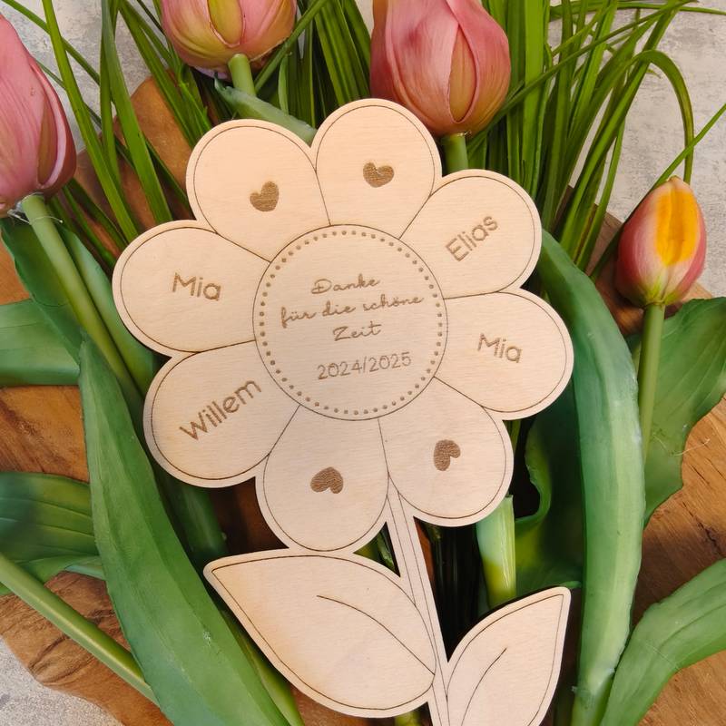 Eine personalisierte Sonnenblume aus Holz in einem Strauß aus echten Tulpen.